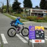 孩子们骑着自行车在杰纳西希尔小学的学校街上上学